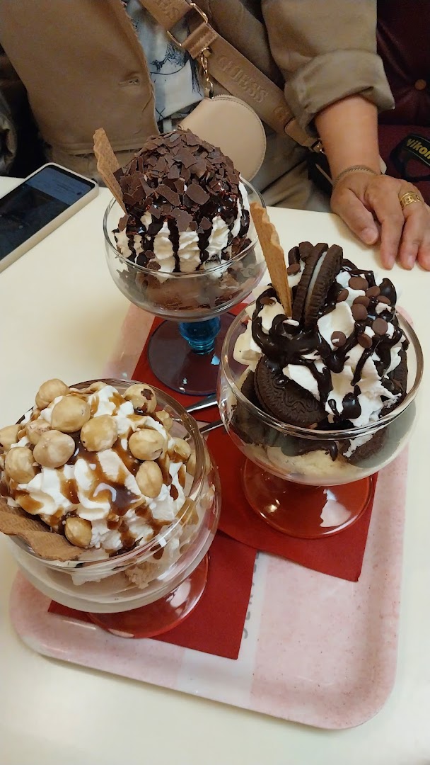 Drei dekorierte Eisbecher mit Sahne und Schokolade