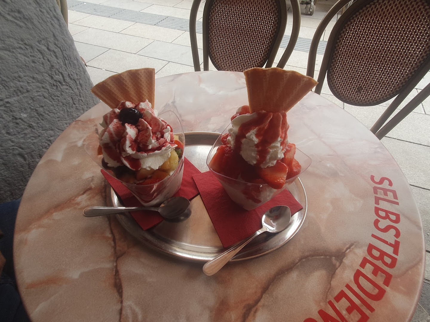 Eisbecher auf einem Tisch vor dem Eiscafé Cortina